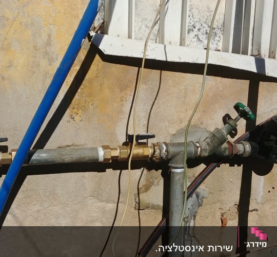 צינורות מים עם ברזים על קיר חיצוני